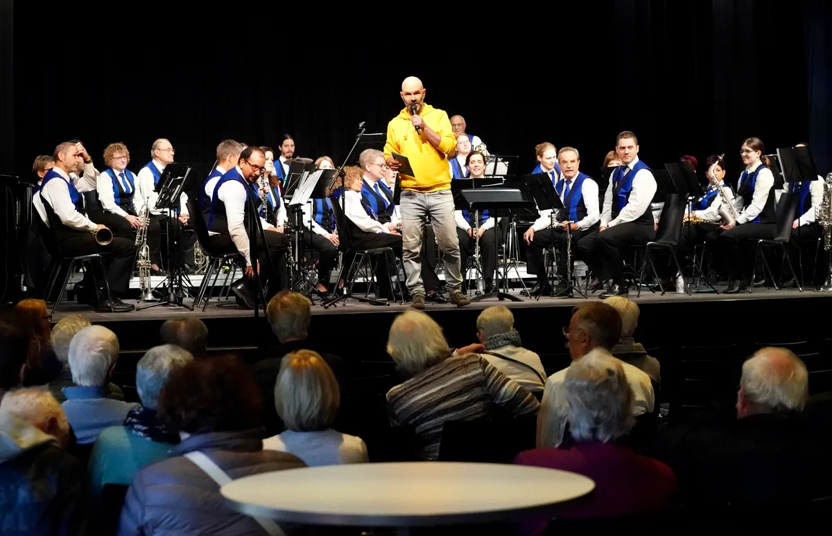 Das Blasorchester der Stadt Dübendorf weihte am Samstag den Konzertsaal des neuen Speichers ein. Ein Mann in einem gelben Pullover steht vor einem Blasorchester.